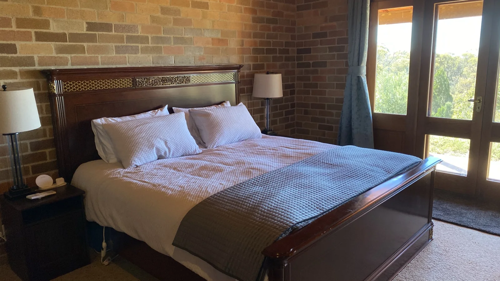 King bedroom with exposed brick and timber details